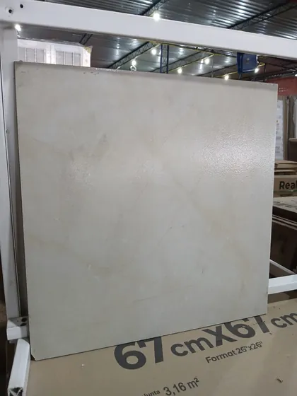 Porcelanato bege 67x67 apoiado na caixa que mostra o rendimento de 3,16 m2